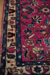 Plush magenta and indigo floral motifs within the border of a vintage Persian Lilihan rug.