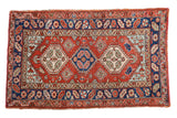 Vintage Heriz rug with a triple geometric medallion in brick red, navy, ivory, and powder blue.