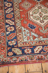 Corner detail of a vintage Heriz rug with serrated leaf motifs in navy blue, brick red, and powder blue.