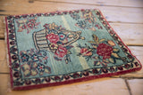 Perspective view of the antique Persian Kerman mat with its finely woven floral bouquet.
