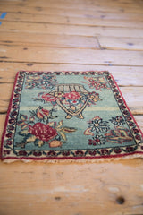 A low angle highlights the soft, even pile of the pictorial antique Kerman rug mat.