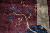 Pictorial detail of a cherry blossom branch with blue flowers on a soft aubergine wool pile.