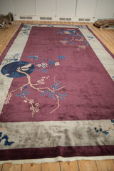 An angled perspective on an antique Art Deco carpet's pictorial design of sprawling cherry blossoms.