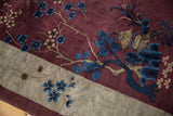 Expressive cobalt blue cherry blossoms on the aubergine wool pile of a pictorial Art Deco carpet.