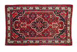 Vintage Bijar rug with a navy blue quatrefoil medallion over a cherry red Herati field.