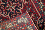 Folded corner of a vintage Persian Bijar rug revealing its dense hand-knotted pile and woven back.