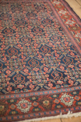 Hand-knotted Senneh rug showing brick red floral guls and navy Herati patterns with even wear.