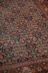 Senneh vintage rug's intricate Herati field and stylized Samovar border in brick red, navy.