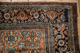 Corner detail of the navy blue Turtle Samovar main border and terracotta tree of life motifs on a Persian rug.