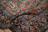 Intricate navy blue Turtle Samovar border on a hand-knotted Persian rug with a terracotta field.