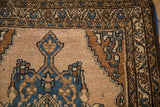 Vintage Mehriban rug detail, geometric medallion and meandering vine border on abrashed field.