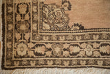 Vintage Tabriz rug corner with coffee and sandalwood floral borders and long ivory fringe.