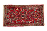 Vintage American Sarouk rug with dense floral bouquets and a central medallion on a cherry red field.