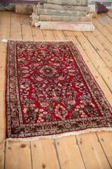 Angled perspective of a vintage American Sarouk rug's dense floral field and dark border.