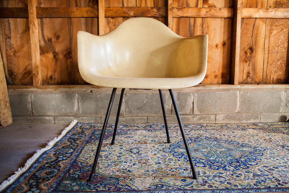 Vintage parchment Eames Herman Miller fiberglass armchair with black X-base.