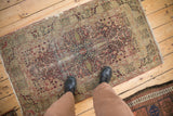 Antique Kerman rug corner, featuring cochineal red and ivory thousand flower motif, with visible wear.