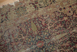 Antique Kerman rug's cochineal red, navy, dusty jade thousand flower pattern with pile wear.