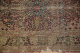 Antique Persian Kerman rug detail: cochineal red, ivory, green florals, exposed foundation, tatter.