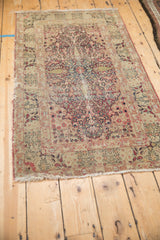 Tattered fringe and intricate floral border with thousand flower motif on antique Kerman rug.