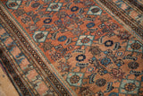 Herati design motif and abrashes in terracotta and blue shades on a vintage Malayer rug.