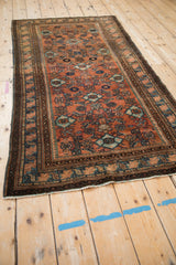 Patinaed terracotta and blue tones on the fully secured end of a Vintage Malayer rug.