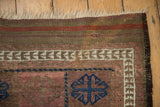 Antique Belouch rug corner with fringed end, striped kilim, geometric border, and blue gul.