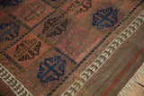 Antique Persian Belouch rug detail: madder red field, cobalt blue ram's horn guls, primitive vine border.