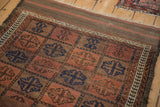 Antique Belouch rug's top edge, showing geometric guls, striped plain weave, and fringe.