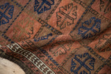 Textured madder red and cobalt blue gul patterns, with a primitive vine border on an antique Belouch rug.