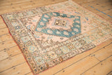 A vintage Anatolian rug's lustrous wool pile and square design, viewed from a high angle.