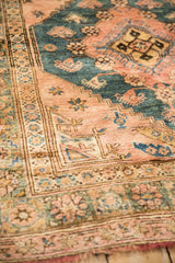 Supple, soft wool pile of a vintage rug showing the stepped corner and floral border.