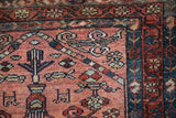 Hand-knotted vintage Mehriban rug detail, dusty raspberry field, repeating boteh border in sapphire blue.