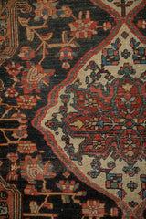 Vintage Josan Sarouk rug: Beige medallion spandrel with palmettes, dark navy field with red blossoms.