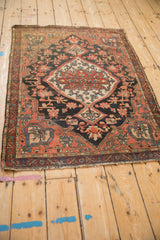 Josan Sarouk rug's secured, worn end, revealing fringed edge and dark navy ground.