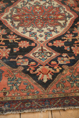 Meandering vine blossoms border and worn fringed end of vintage Josan Sarouk rug.