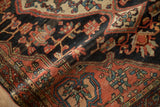 Textured madder root red border with blue vinery on a dark navy vintage Josan Sarouk rug.