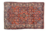 Vintage Persian Tajabad rug with a dense Herati design in gem-like shades of ruby red and sapphire blue.