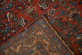 Antique Bijar rug corner folded to show the dense red pile and sturdy hand-knotted back.