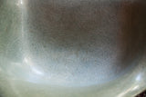 Close-up of the vintage Herman Miller chair's seafoam green shell, with playful fibrous texture.