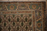 Corner of vintage Sarouk rug: dusty blue serrated floral border, ivory field with green boteh motifs.