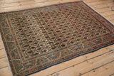 Close-up of vintage Sarouk rug's ivory field with germinating cypress motifs and floral border.