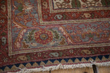 Sarouk rug corner: terracotta and dusty blue floral serrated borders, navy guard, white fringe.