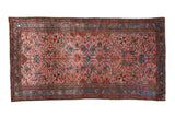 Antique Persian Lilihan rug with sprawling floral vines on a dusty raspberry red field.