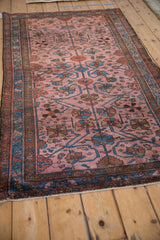 Lustrous pile of an antique Lilihan rug showing its raspberry red field with sapphire blue floral vines.