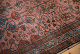 Close view of the antique Lilihan rug's hand-knotted pile showing mostly even wear and floral arabesque designs.