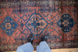 Antique Borchalou rug detail with geometric madder red field, cobalt blue motifs, Serbend border.