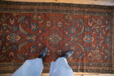 Scrolled florals and palmettes on the time-softened low pile of an antique Mehriban rug.