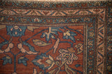 Corner detail of an antique Mehriban rug showing meandering vine and floral top view borders.