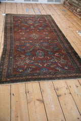 Antique Persian Mehriban rug viewed from an angle, showcasing its allover floral and palmette design.