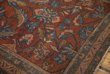 Angled view of an antique Mehriban rug's corner showing floral palmettes and time-softened pile.